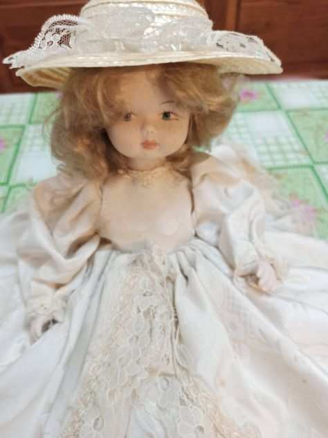 Bambola in Porcellana seduta con vestito molto ampio e con cappello