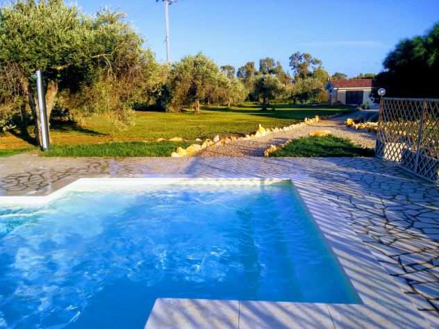 Open space con piscina condivisa in villa ad Alghero