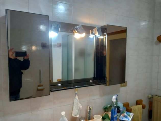 Specchio per bagno con due armadietti.