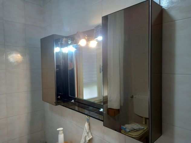 Specchio per bagno con due armadietti.